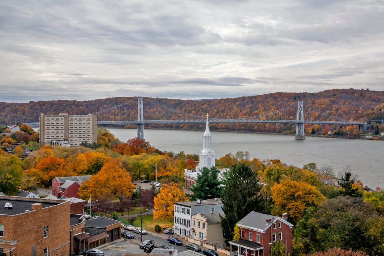 New York State river town in autumn with a suspension bridge in the distance